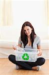 Gorgeous woman with a recycling box in a living room