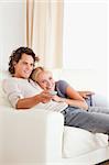 Portrait of a couple cuddling while watching TV in their living room