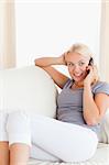 Portrait of a smiling woman making a phone call in her living room