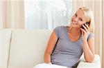 Smiling woman speaking on the phone in her living room