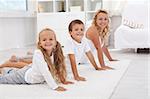 Kids having fum doing some morning gymnastic with thir mother at home - focus on the little girl