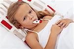 Sick and sad kid in bed holding thermometer between lips