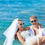 Groom holding up a bride on the beach