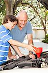 Father and son changing the oil on the family car.