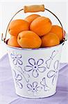 Ripe fresh apricot in white bucket shallow DOF