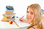 Smiling young girl  sitting at desk and doing homework