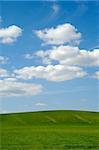 Farm landscape with blue sky and clouds.