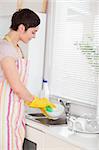 Woman washing the dishes in the kitchen