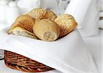 wooden basket covered with white cloth full of small bread