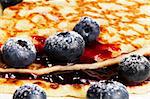 closeup of sugar covered blueberries with jam on pancakes