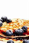 sugar covered blueberries on pancakes with jam on white background