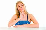 Thoughtful beautiful young girl sitting at table