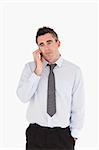 Portrait of a businessman making a phone call against a white background