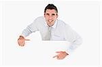 Businessman pointing at blank panel against a white background