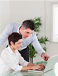 Portrait of a manager and his secretary working with a laptop in an office