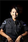 a smiling police officer posing for her portrait in the night.