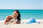 Girl on the beach with a kitten and wearing a hat