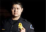 a male police officer pointing his taser gun at night.