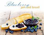 Fresh bread with blueberry jam and fruits on a rustic table, place for your text up