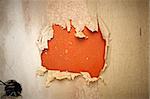 close up of a orange hole in a wallpaper