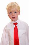 Portrait of a young blond boy wearing a red tie on white background