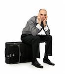 Handsome young man sitting on his luggage