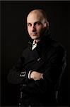 Portrait of young man thinking, black background