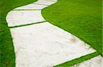 Garden path with grass growing up between the stones