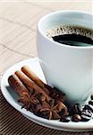 Cup of coffee with cinnamon and coffee beans