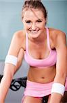Young woman smiling while doing cardio exercise in a gym.