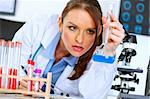 Thoughtful medical doctor woman in laboratory analyzing results of medical test