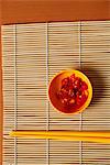 Small bowl of red chillies and chopsticks.