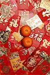 Many different red envelopes, Hong Bao scattered on table with oranges.