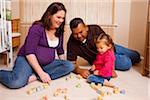 Famille assis sur le plancher avec des blocs de construction