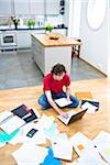 Elevated view of mid- adult man struggling with domestic paperwork