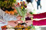 Person buying bunch of flowers from vendor