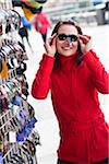 Portrait of young woman trying on sunglasses