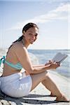 Woman reading on rock, smiling