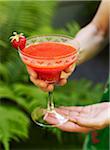 Person holding glass of strawberry drink