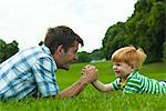 Boy and father arm wrestling