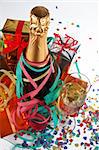 Assortment of gifts with champagne bottle and glass, ribbons and confetti