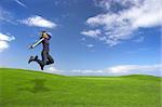 Young woman jumping on the green field