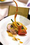 Pistachio nut crusted roast rabbit loin served with forest mushroom, green pea and kidney, rainbow carrot and scallion terrine, pearl onions and natural stock reduction.