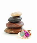 Stack of balanced stones  with bath beads isolated on white background