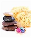 Stack of balanced stones with bath beads isolated on white background