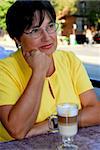 Mature woman in outdoor cafe with coffee