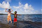 Two young boys playing with snorkel gear in the water - one Caucasian, one African American. John Pennecamp Park, Florida Keys.