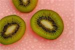 Fresh kiwi fruit with water droplets on a blue background - delicious and nutritious snack.