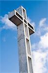 Religious cross against sky background