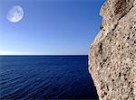 Massive Rock or boulder perched right on the very edge of cliff leading to ocean, in Malta